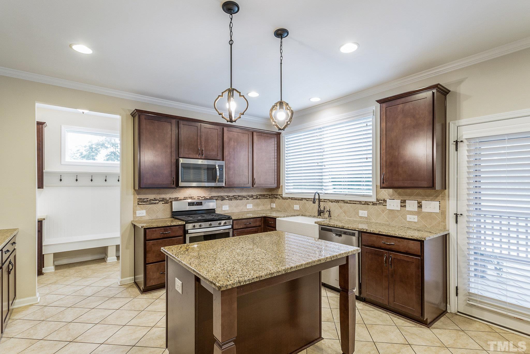 1214 Raleigh Street Oxford, NC 27565 - Photo 17 of 40 a kitchen with a stove a sink and a refrigerator