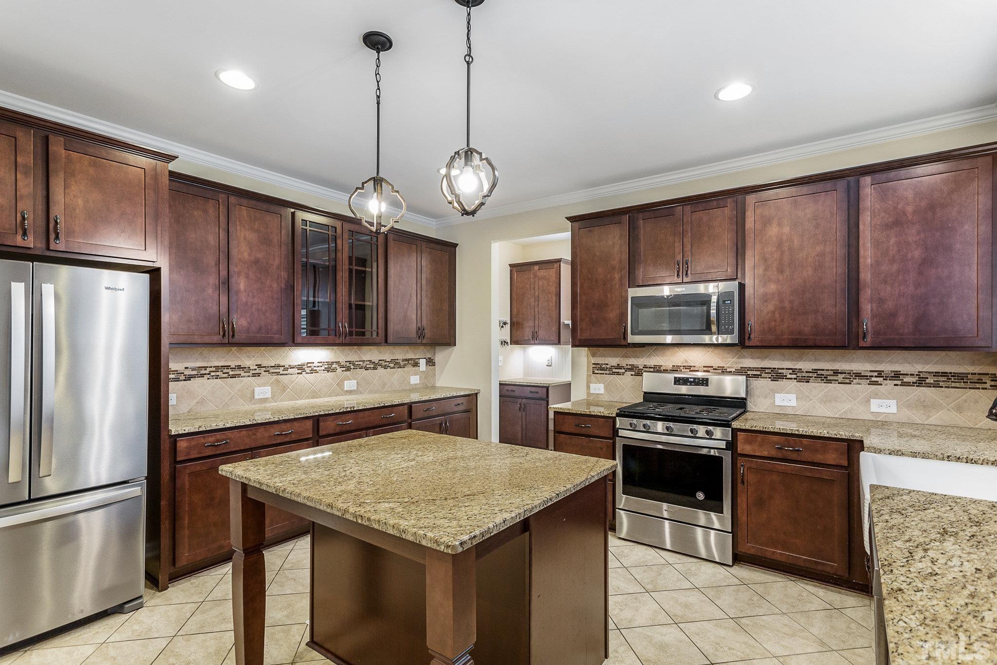 1214 Raleigh Street Oxford, NC 27565 - Photo 18 of 40 a kitchen with stainless steel appliances granite countertop wooden cabinets a stove a sink and a refrigerator