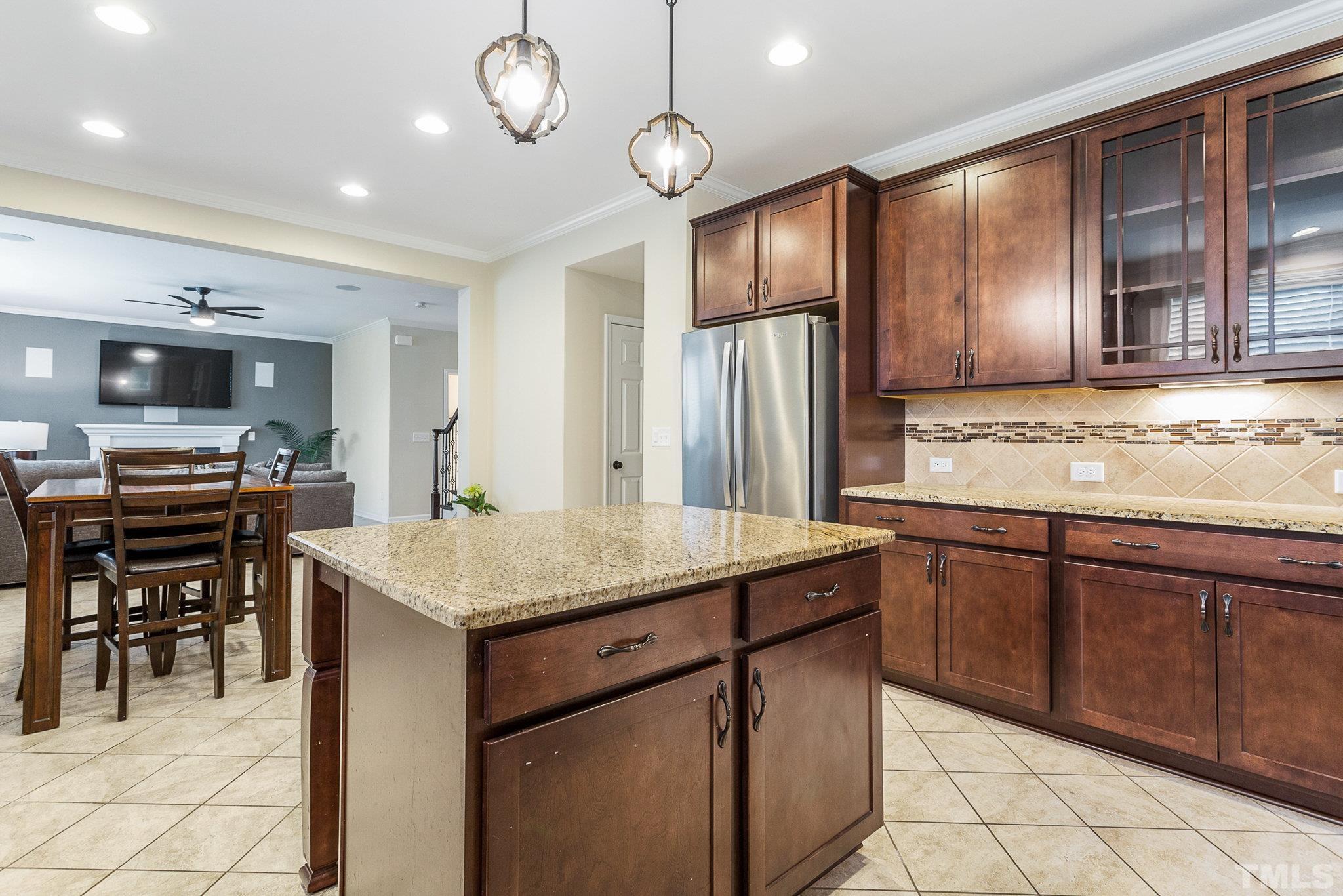 1214 Raleigh Street Oxford, NC 27565 - Photo 19 of 40 a kitchen with stainless steel appliances granite countertop wooden cabinets a dining table and chairs