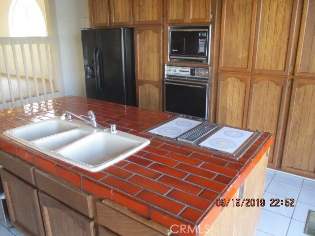 a kitchen with kitchen island a counter top space and stainless steel appliances wooden floor