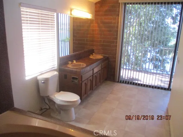 a bathroom with a toilet a sink and a window