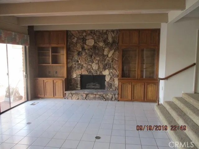 a view of a livingroom with a fireplace and window