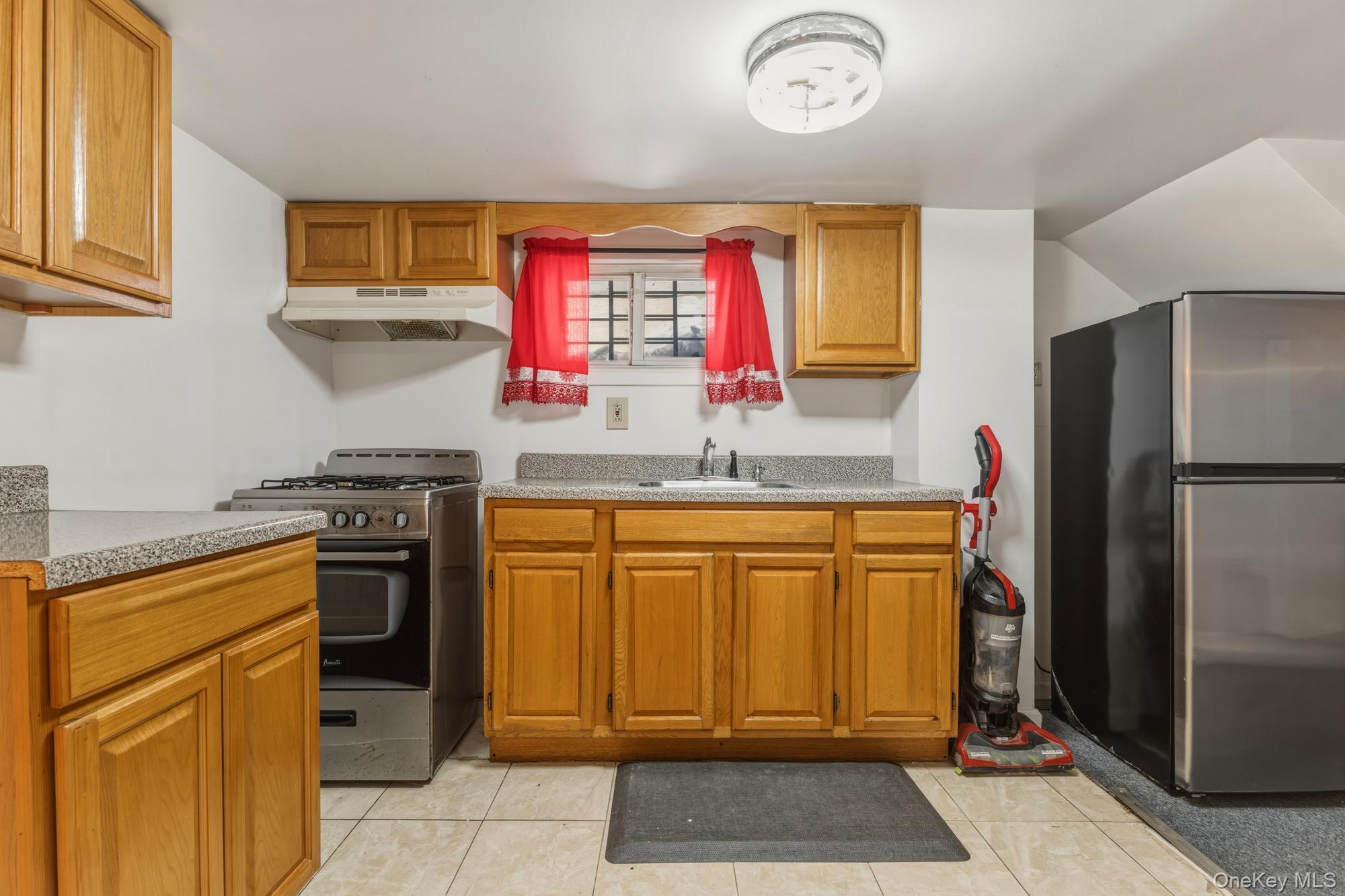 188-11 Dormans Road Queens, NY 11412 - Photo 16 of 32 a kitchen with stainless steel appliances granite countertop a refrigerator and a stove