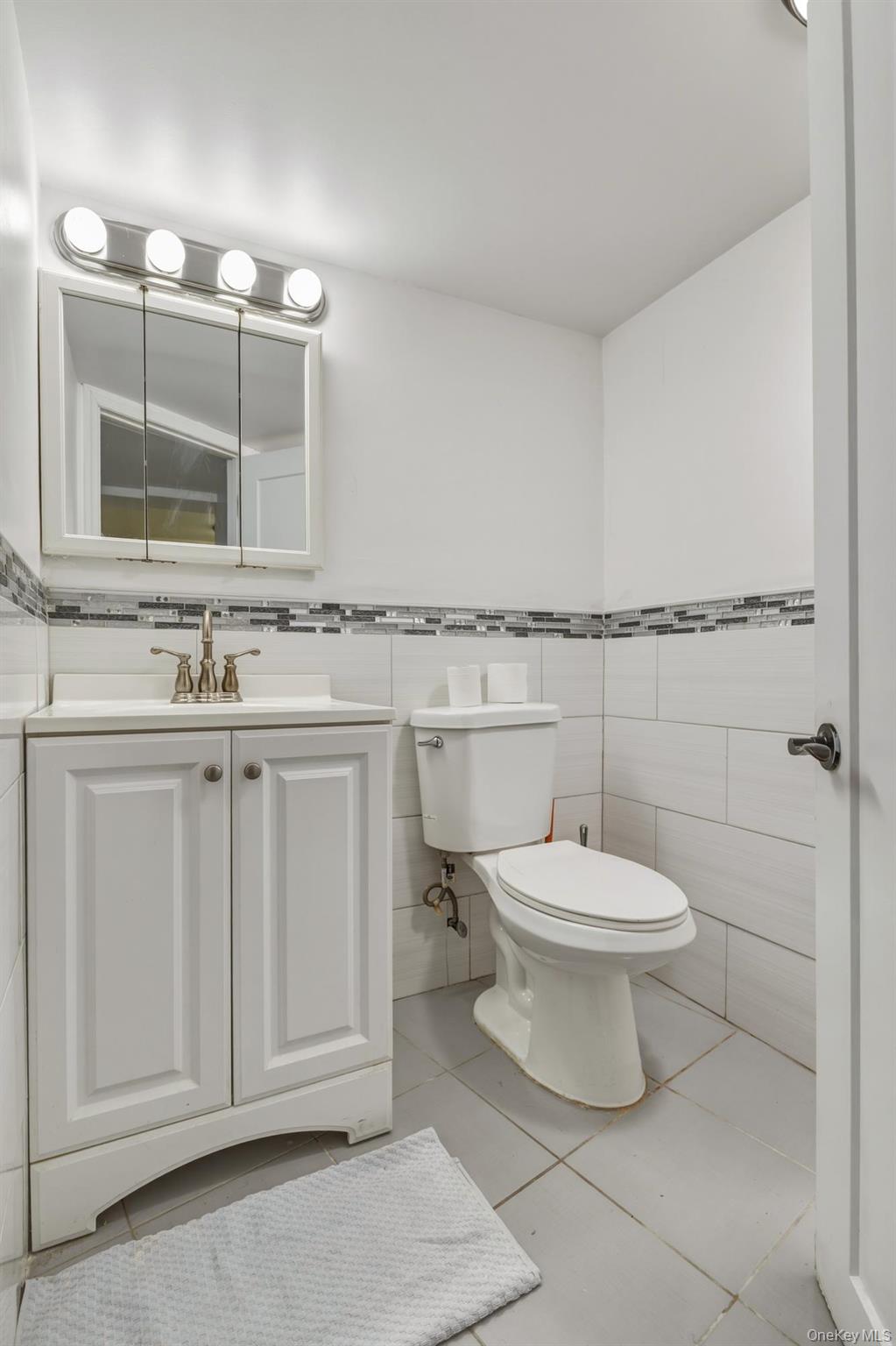 188-11 Dormans Road Queens, NY 11412 - Photo 18 of 32 a bathroom with a toilet a sink and mirror