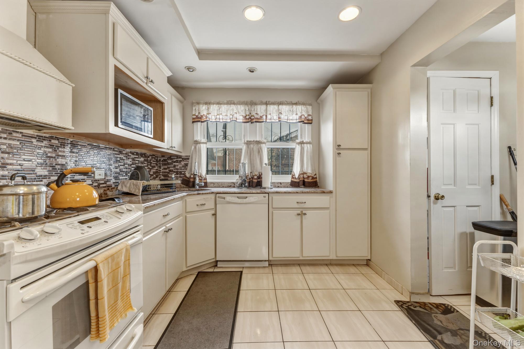 188-11 Dormans Road Queens, NY 11412 - Photo 9 of 32 a kitchen with a sink stove and cabinets