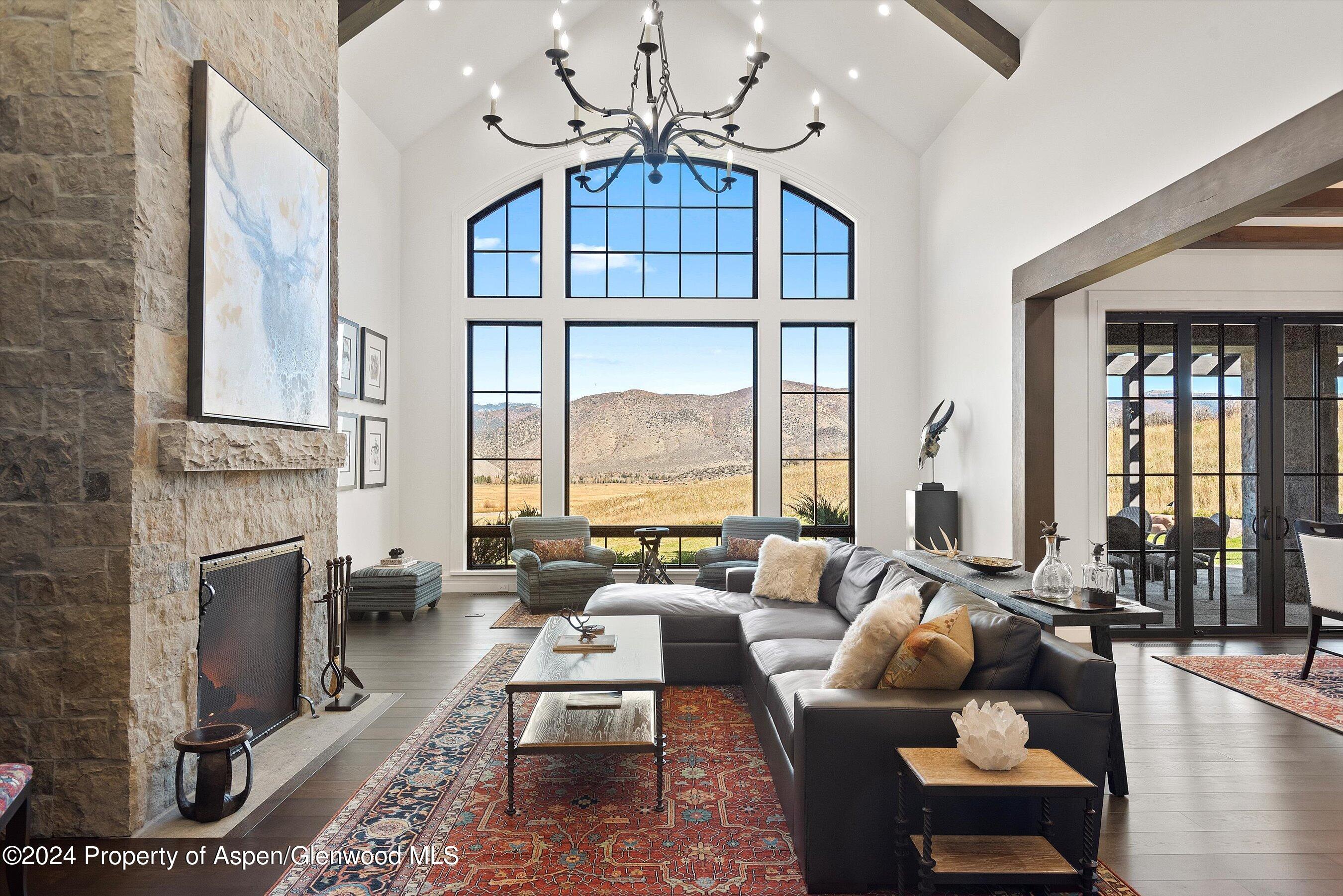2388 Lazy O Road Snowmass, CO 81654 - Photo 7 of 65 a living room with furniture a fireplace and a chandelier