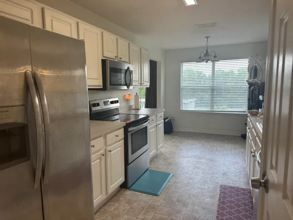 a kitchen with stainless steel appliances a refrigerator sink and microwave