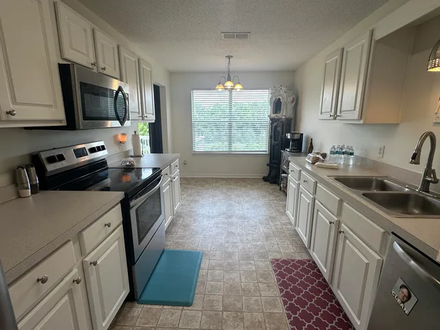 a kitchen with stainless steel appliances a sink stove microwave and refrigerator