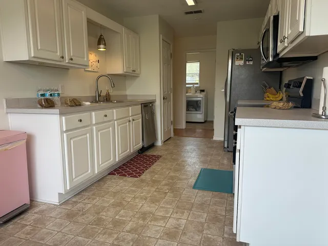 a kitchen with stainless steel appliances granite countertop a refrigerator and a stove