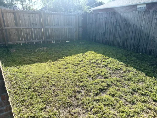 a view of a yard with a wooden fence