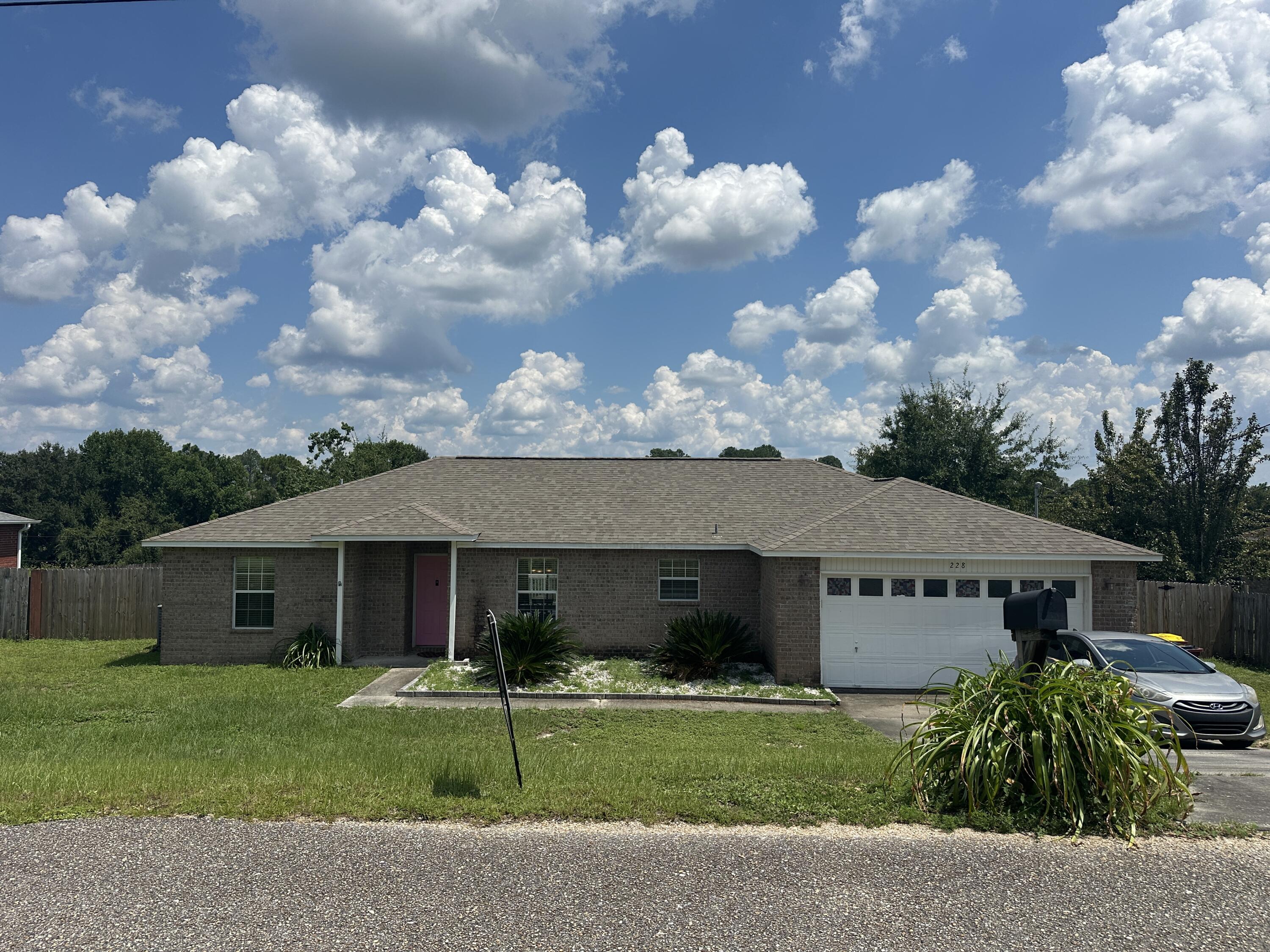 228 Trish Drive Crestview, FL 32536 - Photo 29 of 34 a front view of a house with a garden and trees