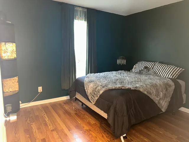 a bed sitting in a bedroom next to a window