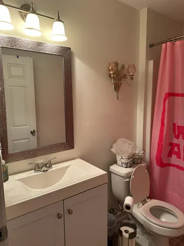 a bathroom with a sink mirror vanity and toilet