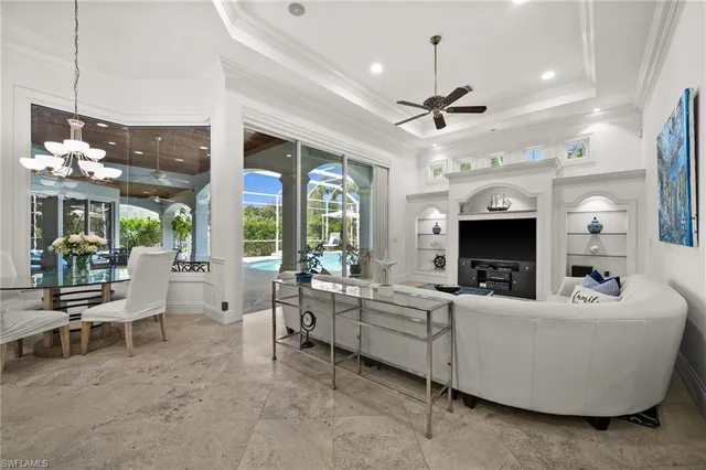 a living room with furniture a chandelier and a flat screen tv