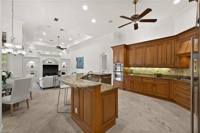 a kitchen with stainless steel appliances kitchen island granite countertop a stove top oven a sink a dining table and chairs