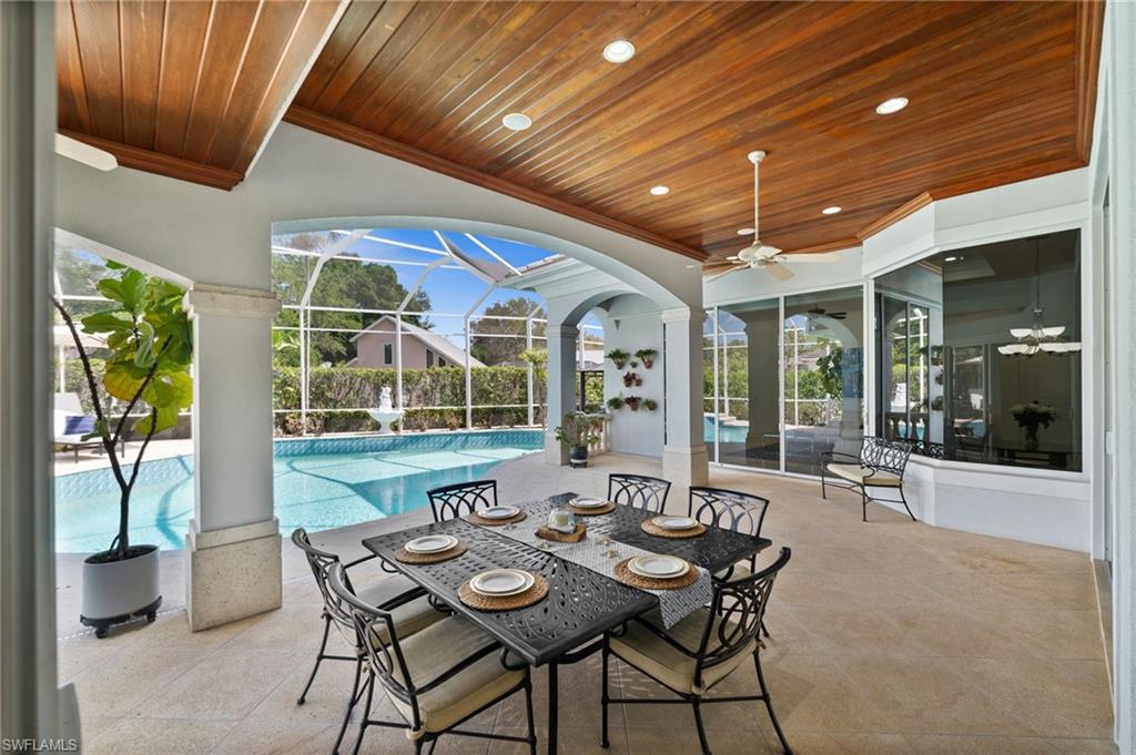 6898 Mill Run Road Naples, FL 34109 - Photo 22 of 38 a view of a patio with table and chairs potted plants with floor to ceiling window and potted plants