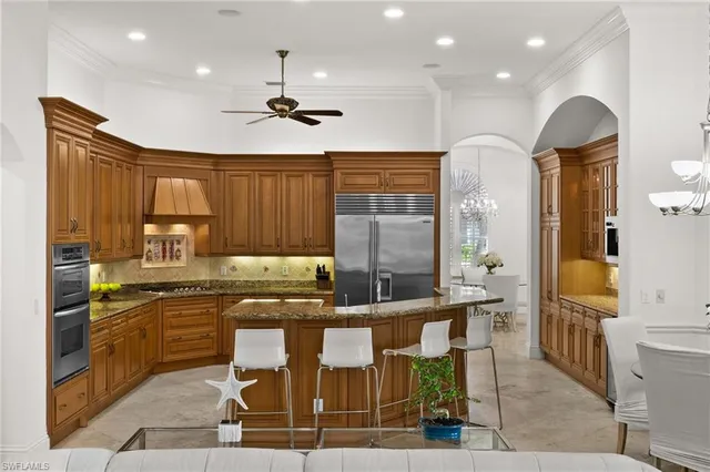 a kitchen with granite countertop a sink cabinets and stainless steel appliances