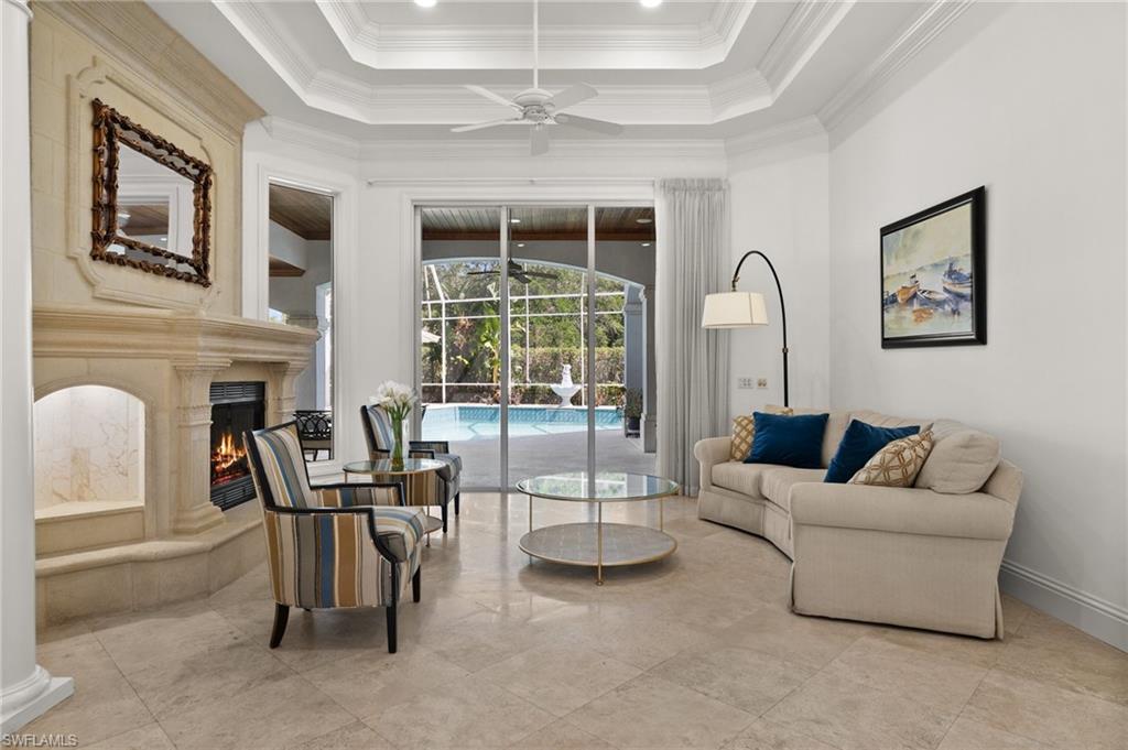 6898 Mill Run Road Naples, FL 34109 - Photo 7 of 38 a living room with furniture a fireplace and a flat screen tv