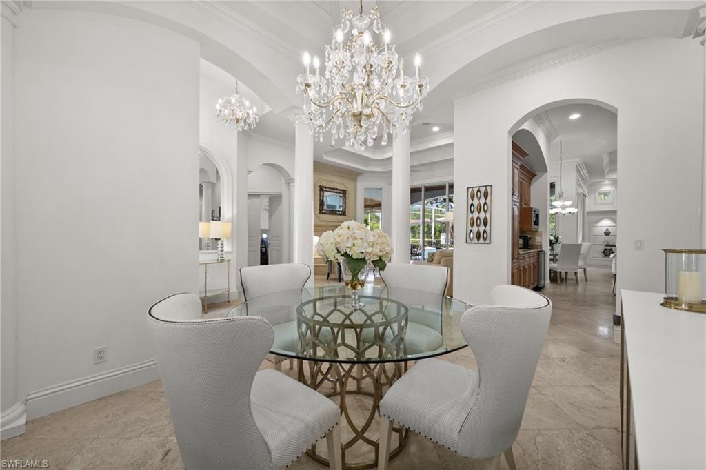 6898 Mill Run Road Naples, FL 34109 - Photo 10 of 38 a living room with fireplace furniture and a chandelier