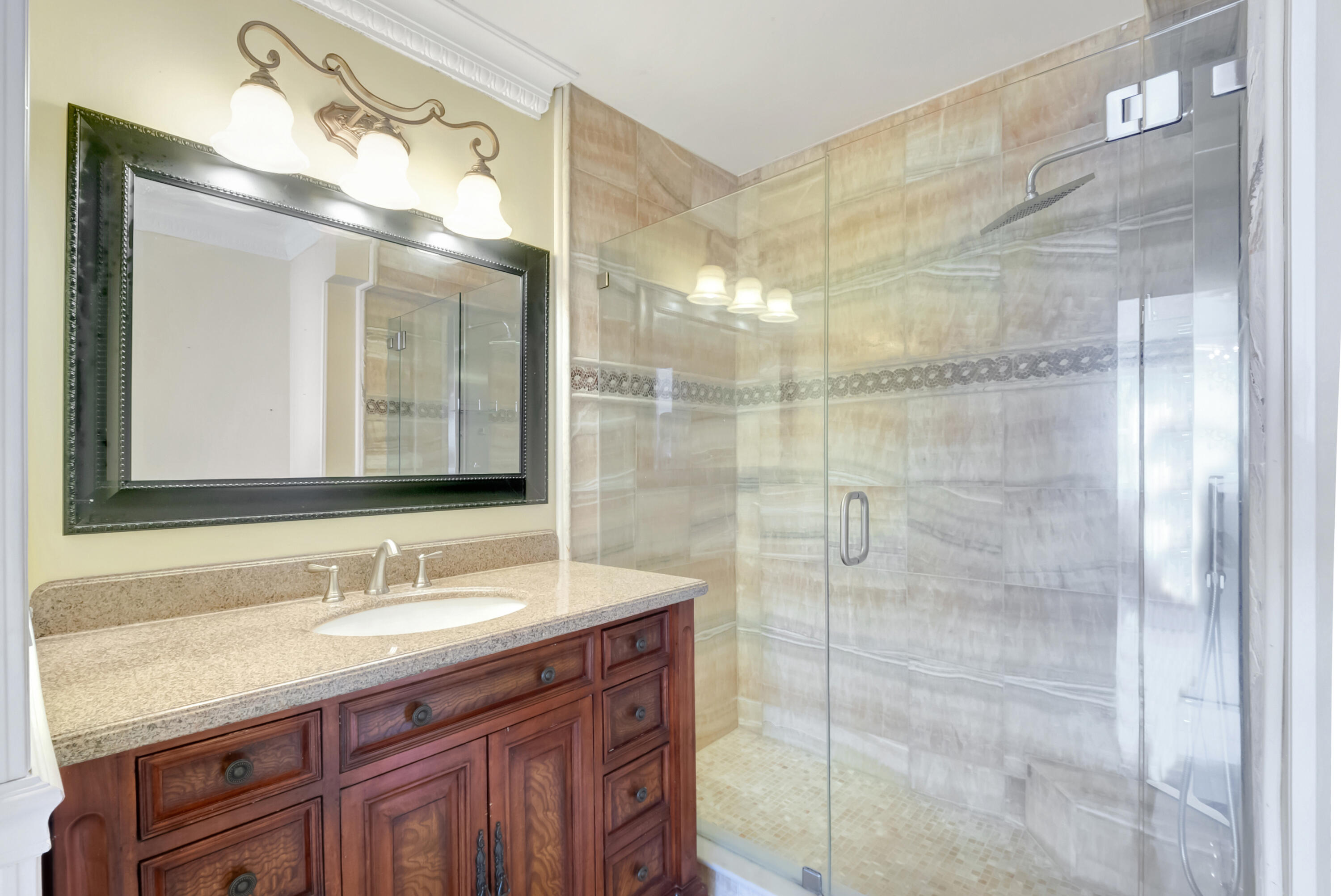 2871 North Ocean Boulevard, Unit C205 Boca Raton, FL 33431 - Photo 20 of 97 a bathroom with a granite countertop sink a mirror and a shower