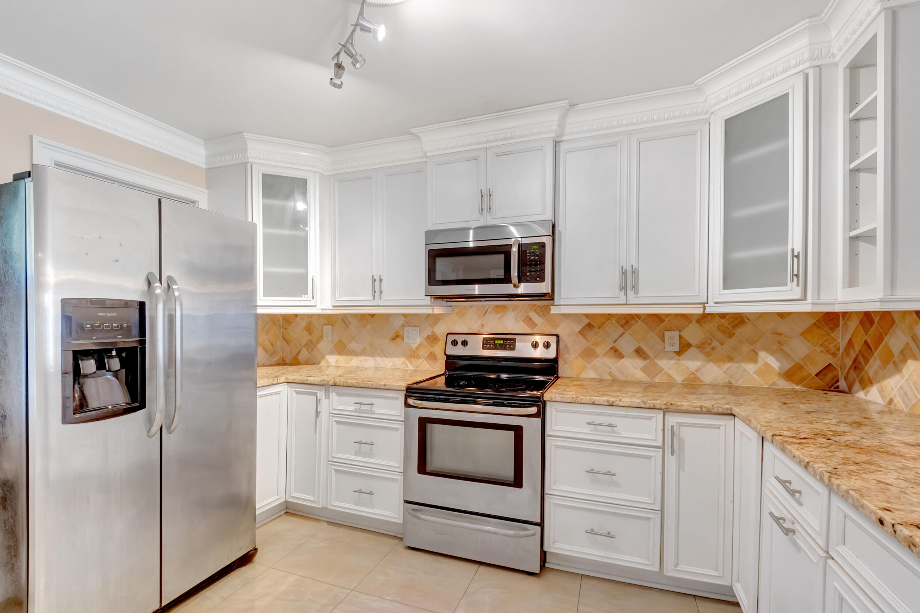 2871 North Ocean Boulevard, Unit C205 Boca Raton, FL 33431 - Photo 3 of 97 a kitchen with granite countertop white cabinets and stainless steel appliances