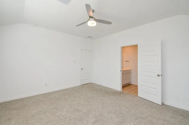 an empty room with a ceiling fan and window