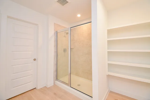 a bathroom with a shower and a glass door