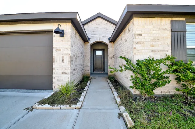 a view of a brick house with potted plants