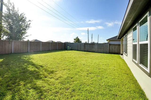 a yellow house with yard in front of it