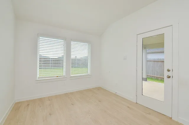 an empty room with a window and a bathroom