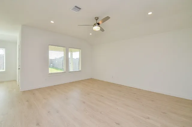 an empty room with a window and a fan