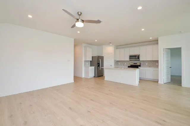 a view of kitchen with kitchen island and stainless steel appliances