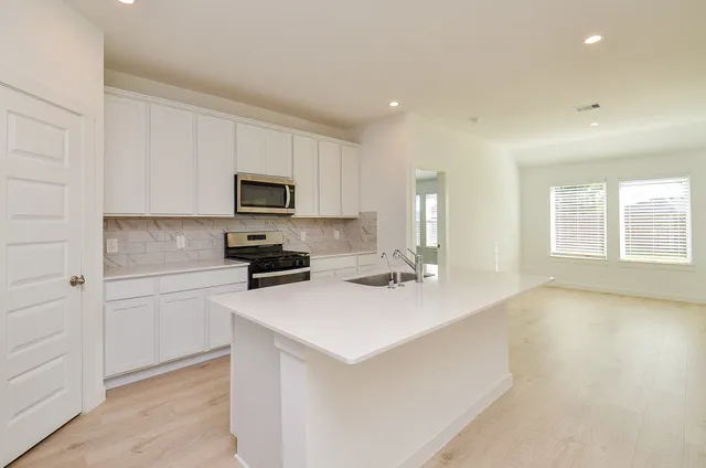 a kitchen with a stove a sink and a microwave