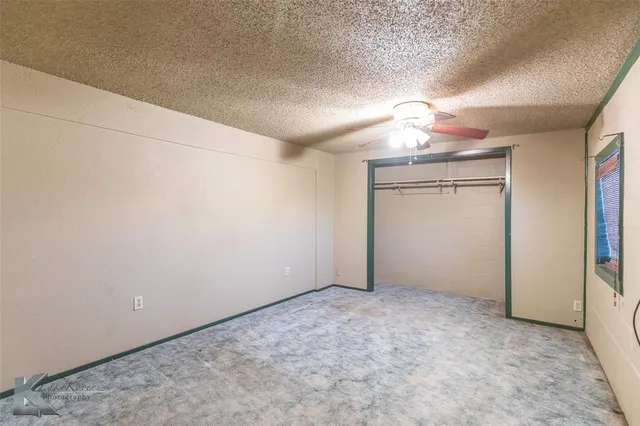 en empty room with ceiling fan and window