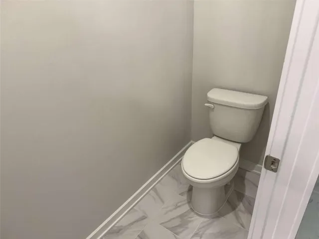 a white toilet sitting next to a white cabinet