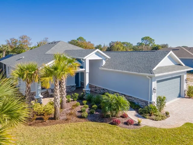 a front view of a house with a yard and a garden