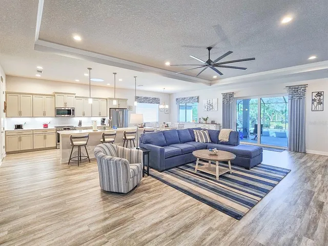 a living room kitchen with furniture and a wooden floor