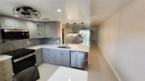 a kitchen with granite countertop a sink and cabinets