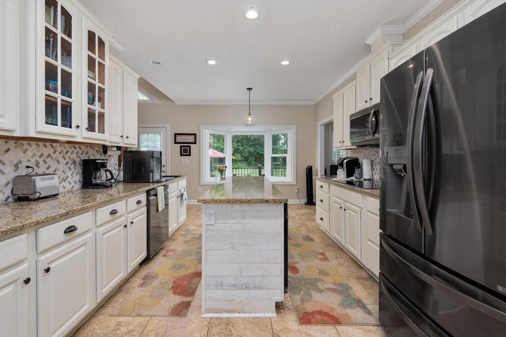 211 Oak Hollow Road Manchester, TN 37355 - Photo 3 of 31 a large kitchen with stainless steel appliances kitchen island granite countertop a refrigerator oven a sink dishwasher and white cabinets with wooden floor