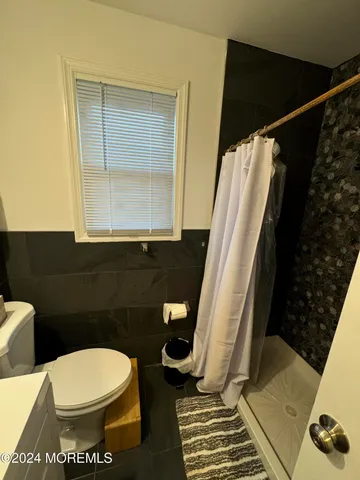 a bathroom with a toilet and a shower
