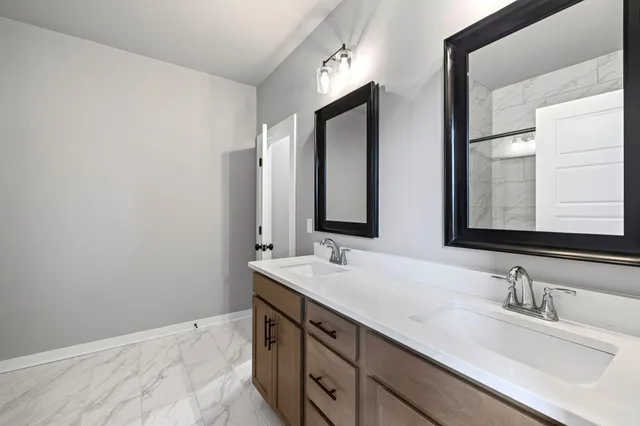 a bathroom with double sink and a mirror
