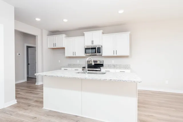 a kitchen with granite countertop a sink stove and refrigerator