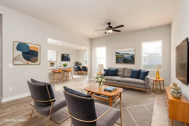 a living room with furniture a flat screen tv and kitchen view