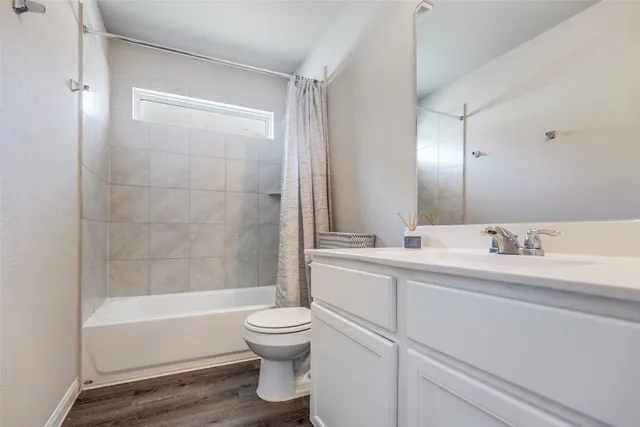 a bathroom with a bathtub shower sink vanity and toilet