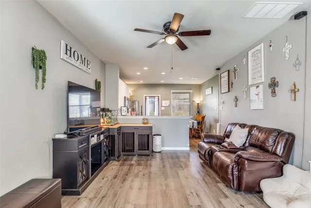 a living room with stainless steel appliances kitchen island granite countertop furniture a rug kitchen view and a chandelier