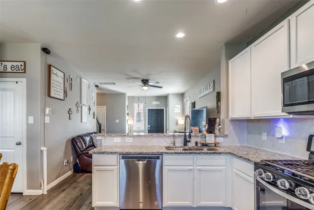 a kitchen with stainless steel appliances granite countertop a sink stove and cabinets