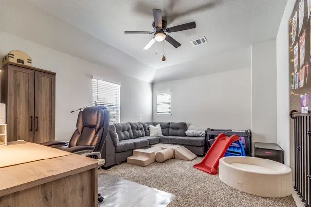 a living room with furniture a air conditioner vent and a window