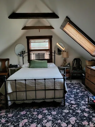 a bedroom with a bed lamp and a fireplace