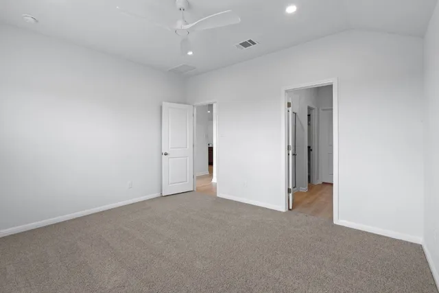 an empty room with an entryway and fan