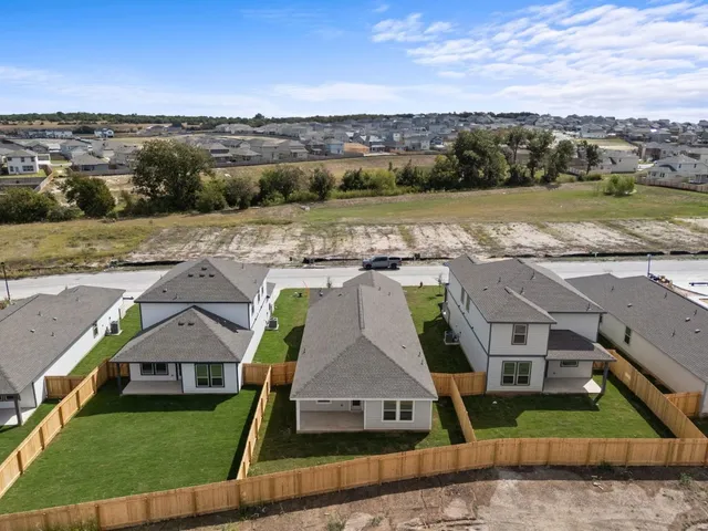 an aerial view of residential houses with outdoor space and ocean